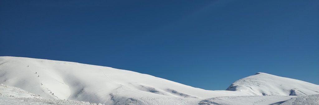 Camminare o ciaspolare in montagna nelle ore centrali quando il sole brilla di più, accende il bianco della neve e ti fa respirare meglio l'aria pura!