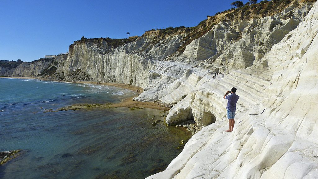 quello che provi stando lì, con l'obiettivo puntato; una sequenza di sensazioni intense e quasi cinematiche: lo shock del bianco; la marna calcarea non è semplicemente bianca, è una luce quasi accecante che fluttua tra l'azzurro del cielo e il turchese del mare, ipnotizzando lo sguardo. La vertigine della storia; calpestare quei gradini naturali levigati dal vento ti fa sentire piccolo, sospeso in un paesaggio antico dove un tempo approdavano i pirati saraceni. La caccia alla linea perfetta; fotografarla è una sfida geometrica esaltante, dove cerchi di catturare le curve morbide della roccia che sembrano onde di pietra modellate dal tempo. L'isolamento sensoriale; mentre metti a fuoco, il rumore del mondo si azzera, lasciando spazio solo al vento sulla pelle e al respiro del mare sottostante.