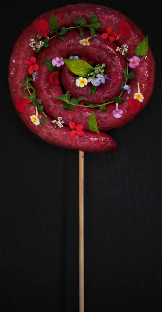 è la magia di trasformare un pasto qualunque in un momento di gioco e meraviglia, la gioia di stupire e far sorridere i miei nipoti a tavola. Il cibo può diventare pura fantasia: una semplice e gustosa salsiccia della tradizione si trasforma, come per magia, in un lecca-lecca gigante e colorato, decorato con fiori eduli, come se fosse appena sbucato da un prato delle favole; veder brillare i loro occhi prima ancora del primo morso trasformando il pranzo in una festa che nutre il corpo e accende l'allegria.