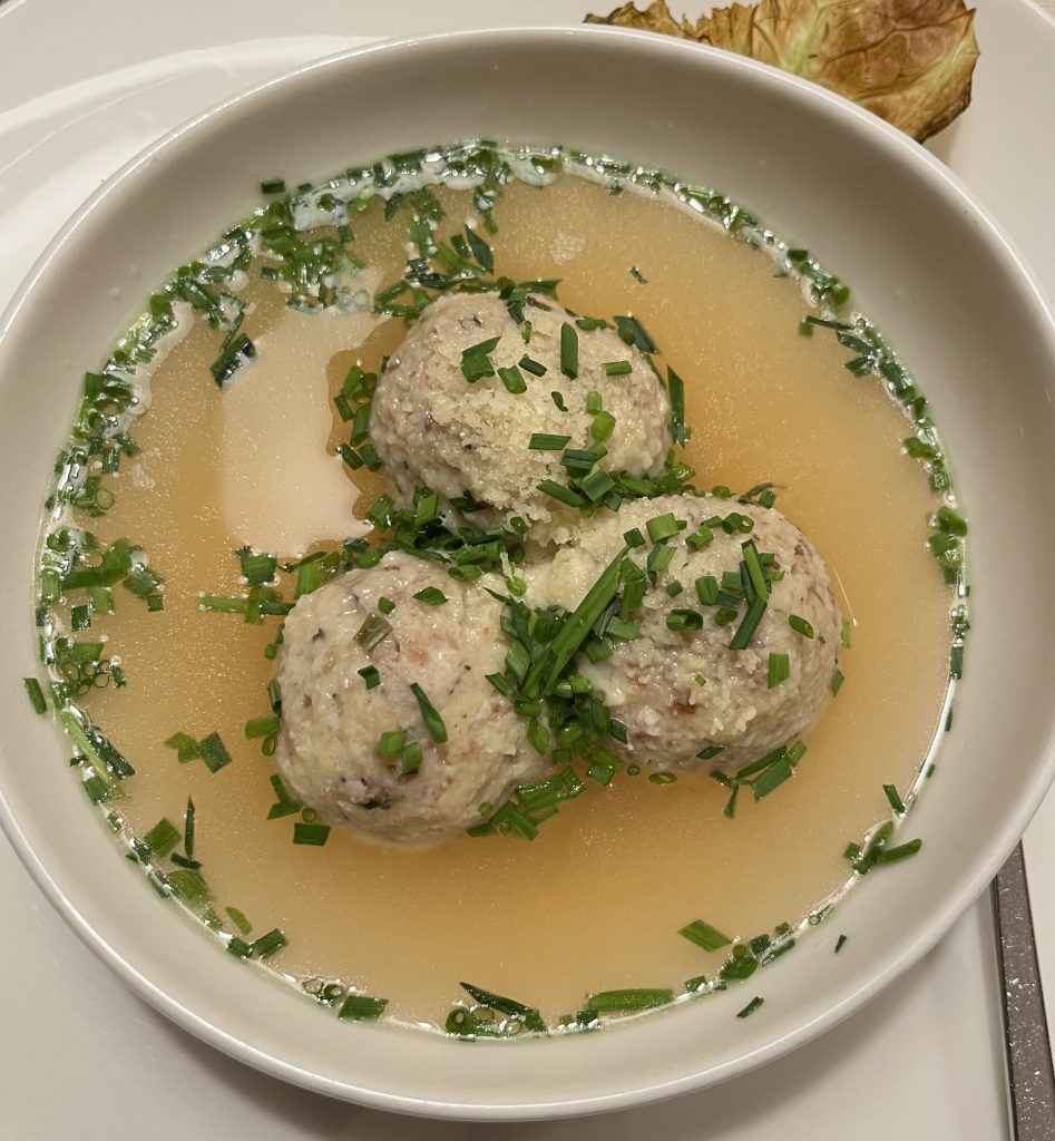 Quando viaggio in Italia, seguo i sapori della tradizione. A Trento ho assaggiato i canederli in brodo: un comfort di montagna, antico e autentico.