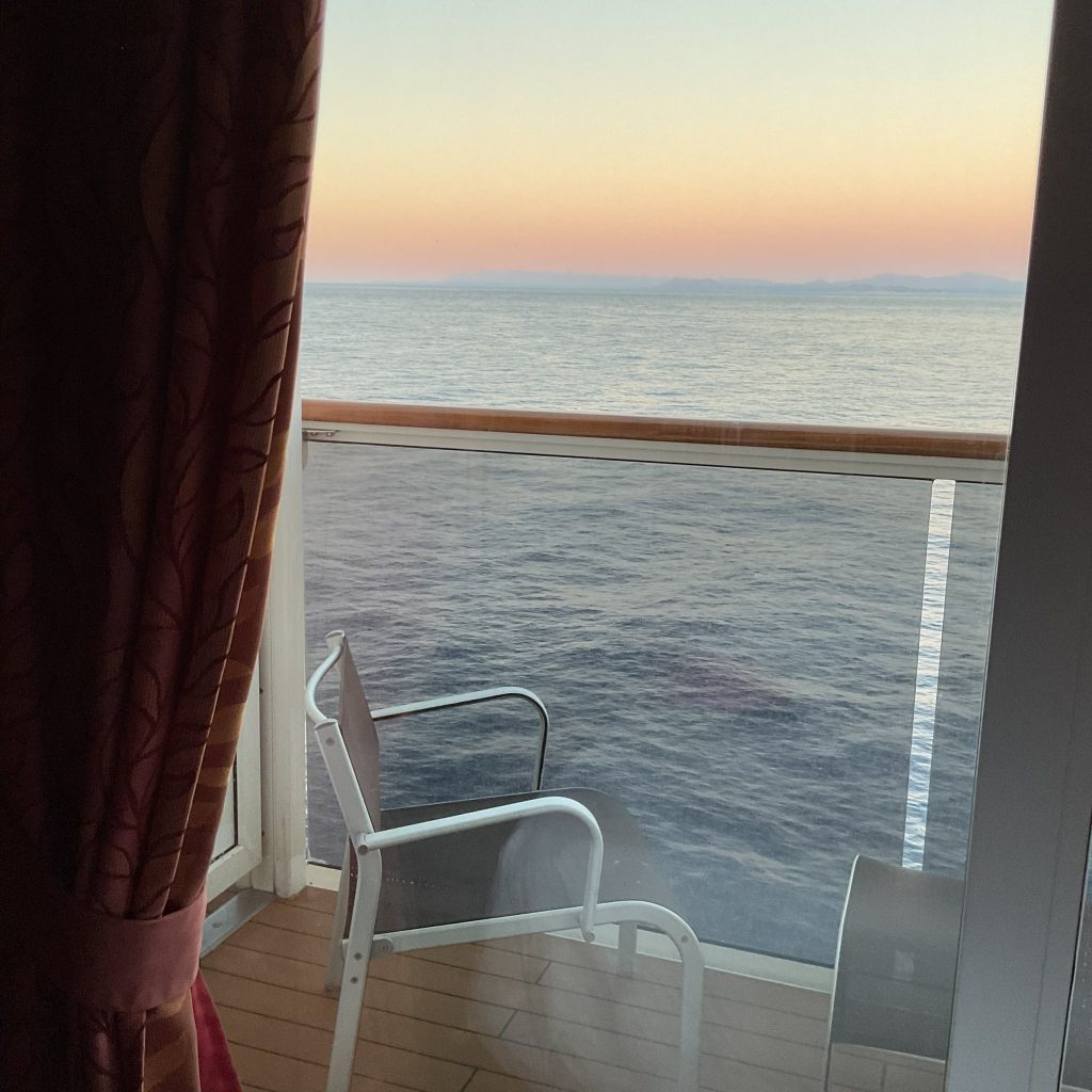 Un balcone, una nave da crociera e un mare calmo, e perdere lo sguardo nei colori delicati dell’alba, è un invito alla quiete. Uno di quei momenti sospesi in cui l’anima respira e ritrova il proprio centro.