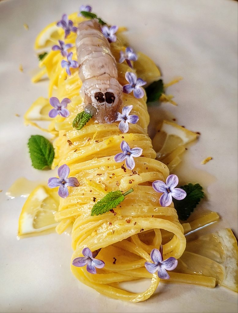 Un equilibrio perfetto tra gusto e salute in questo primo piatto dove la freschezza del limone incontra la leggerezza dei crostacei.
I fiori eduli e la melissa regalano un tocco cromatico e detox per nutrire il corpo e lo spirito con eleganza.