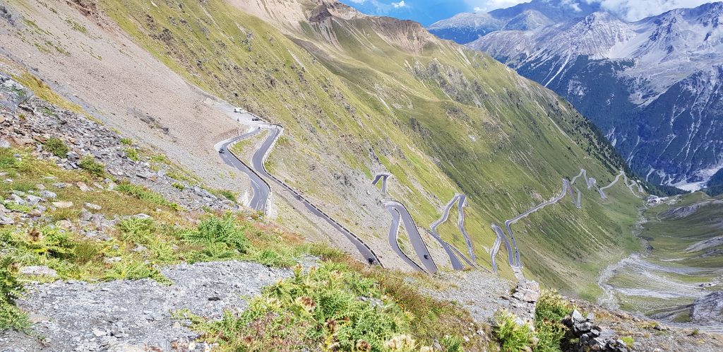 ammirare la strada a zig zag tra l'imponenza delle montagne e la prima timida erbetta di primavera baciata dal sole tiepido dietro le nubi