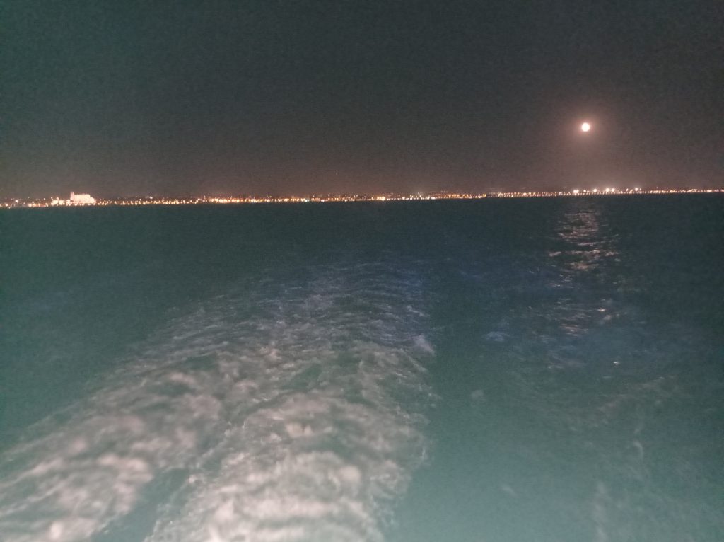 Guardare la scia della nave nel buio della motte e le luci all'orizzonte. Benessere per il corpo e per la mente