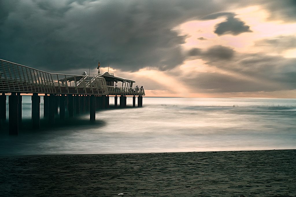 Camminare al tramonto su un pontile proteso in un mare di seta