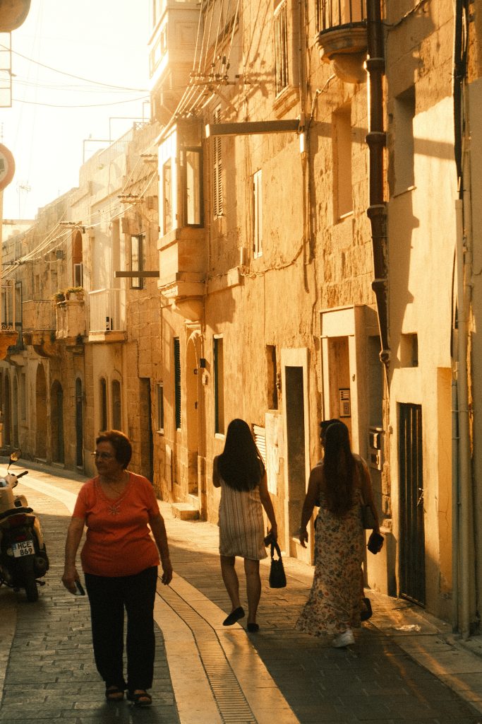 Due generazioni sullo stesso cammino: chi va verso il futuro, chi torna con un bagaglio di vita. Il tempo ci attraversa in direzioni diverse, ma la strada è una sola.