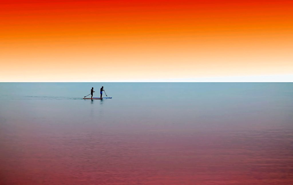 pagaiare sulle acque al tramonto mentre il sole si tuffa dolcemente nel mare, una pura estasi per il benessere del corpo e dello spirito