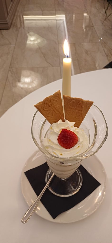 Chiudere una cena con una fragola, come sigillo di dolcezza su una montagna di panna.